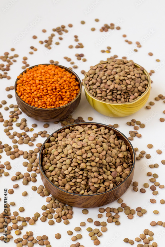 Dry,Red and Green Lentils are in wooden bowls on white surface with lentil seeds. Dry,Red and Green Lentils are in wooden bowls on white surface with lentil seeds.
