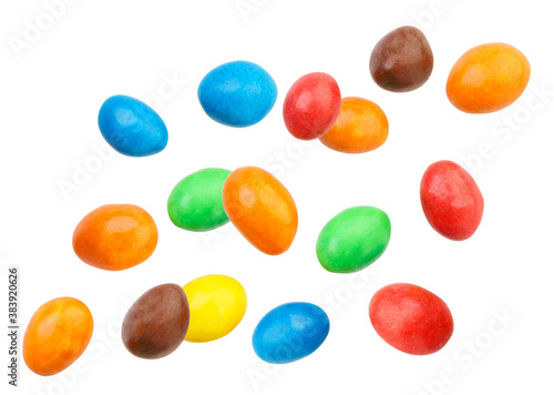 Candy peanuts covered with chocolate in a multicolored glaze fly on a white background. Isolated photo