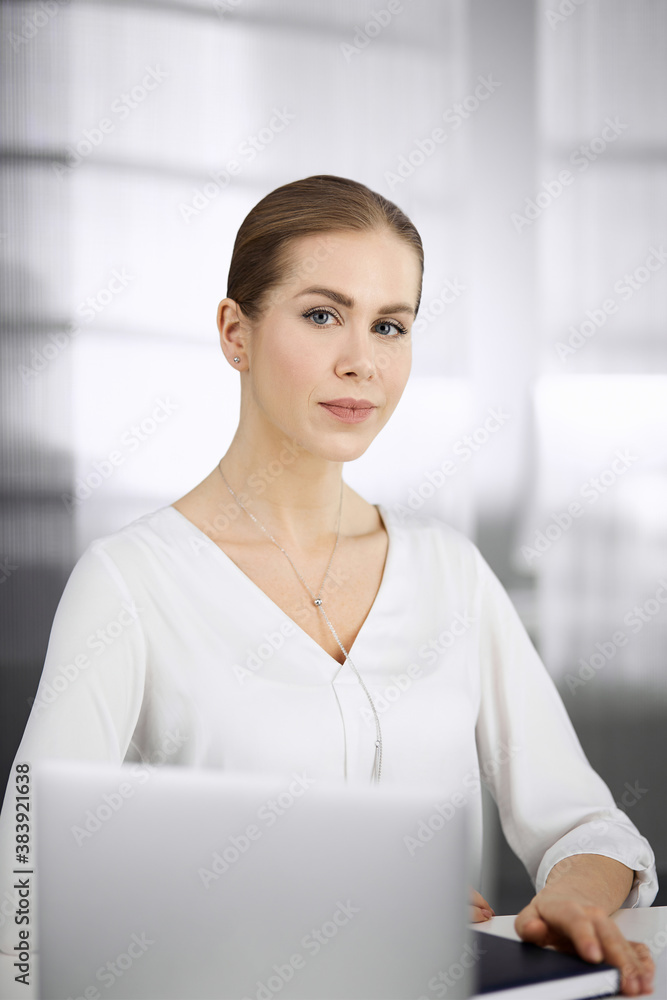 Businesswoman sitting and looking at camera in office. Business headshot Businesswoman sitting and looking at camera in office. Business headshot