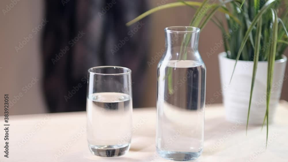 Transparent vessel with liquid on a pink background. Hard shadows. close up Transparent vessel with liquid on a pink background. Hard shadows. close up