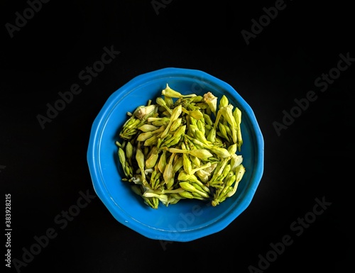 Fernaldia pandurata loroco flower on a plate on black background, typical food of Guatemala photo