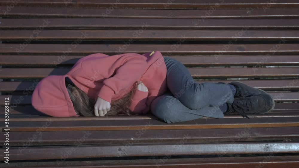 Sleeping homeless child. Teenage girl sleeping on a park bench. Stock ...