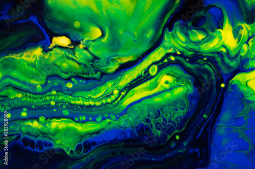 Fluid art texture. Backdrop with abstract mixing paint effect. Liquid acrylic artwork with flows and splashes. Mixed paints for baner or wallpaper. Green, blue and yellow overflowing colors photo