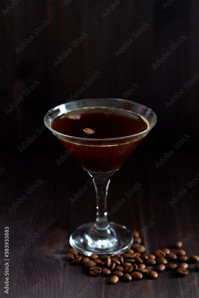 alcohol drinks on black background. glass of espresso martini cocktail. cup of espresso with coffee beans and cinnamons sticks on dark wooden table. vertical