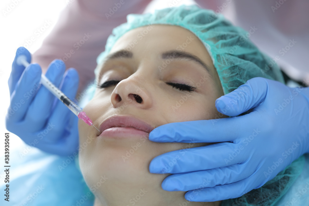 Portrait of woman whose lips are injected by beautician. Hyaluronic acid injections into lips concept Portrait of woman whose lips are injected by beautician. Hyaluronic acid injections into lips concept