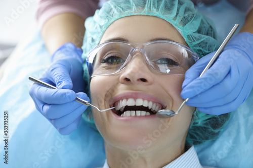 Woman's oral cavity is examined at dentist's office. Dental services concept