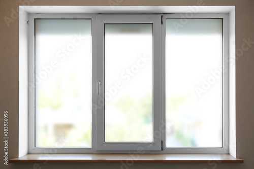 Modern plastic window with empty sill indoors