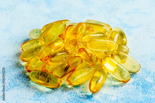Fish oil capsules on a blue background - omega 3 vitamins and health concept