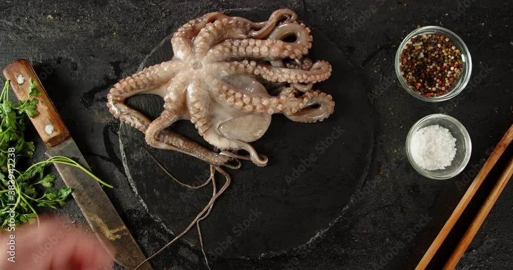 On a stone board put raw octopus. On a stone board put raw octopus.