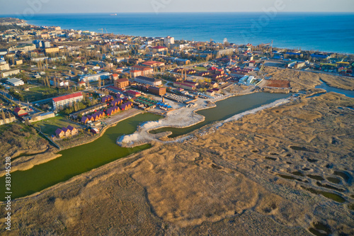 Aerial drone view of a township by the sea during sunset.