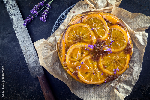 Traditional orange chocolate cake offered as top view on on a rustic grid photo