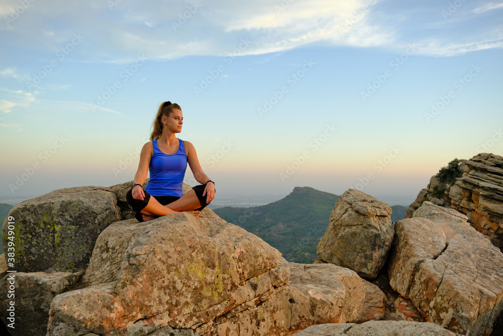 young beautiful girl meditating girl on the mountain