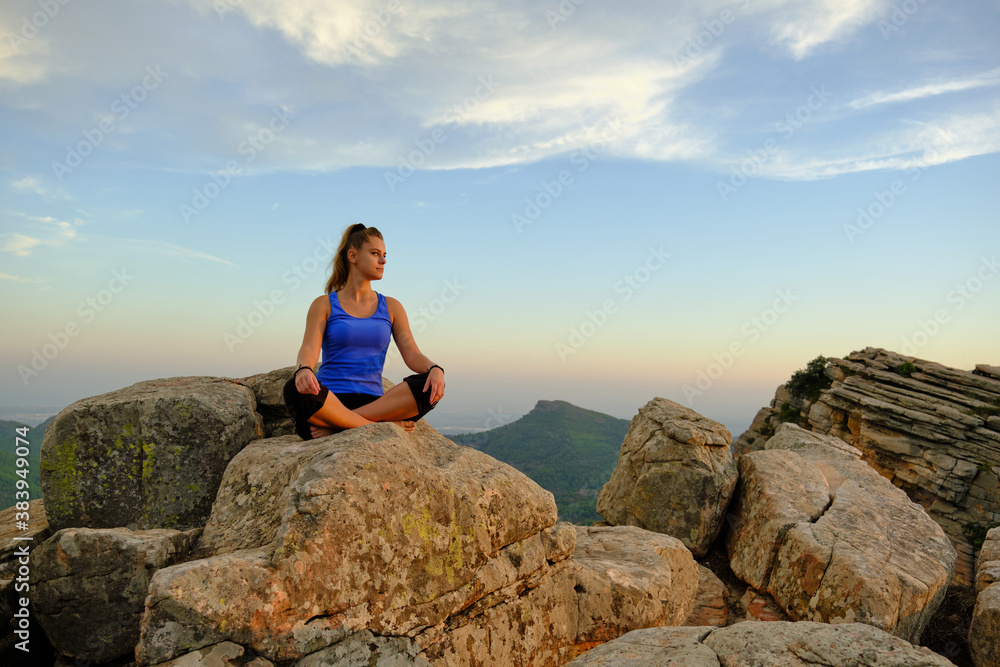 young beautiful girl meditating girl on the mountain