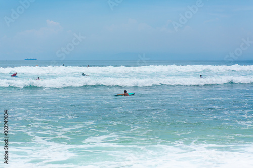 The guy is swimming on the surf board on the ocean. Healthy active lifestyle in summer vocation.
