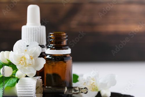 natural cosmetic product, jasmine oil with glass bottles on a wooden table