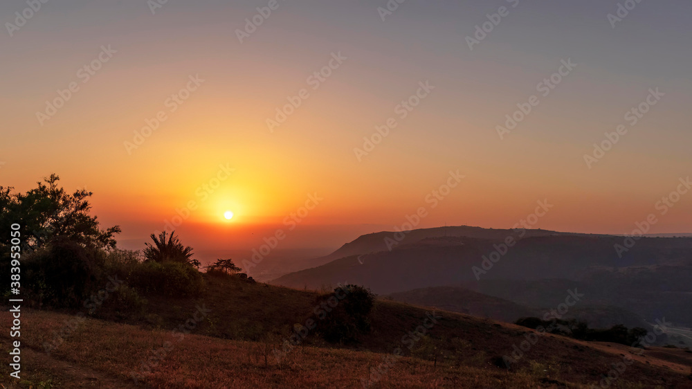 sunset with trees and plants and mountains in salalah