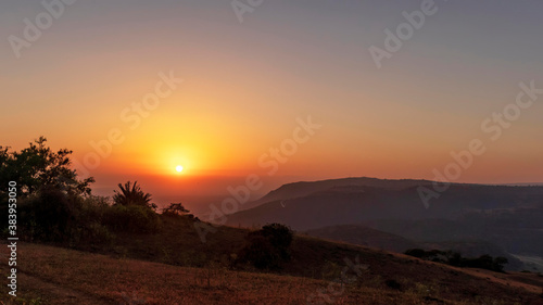 sunset with trees and plants and mountains in salalah