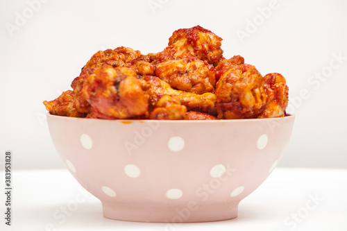 Buffalo chicken wings in a plate on a white background, copy space