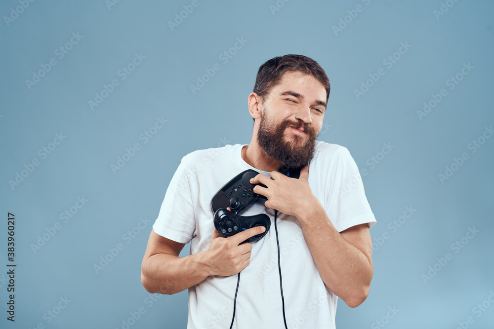 man holding gamepads games lifestyle technology console emotions white t-shirt blue background man holding gamepads games lifestyle technology console emotions white t-shirt blue background