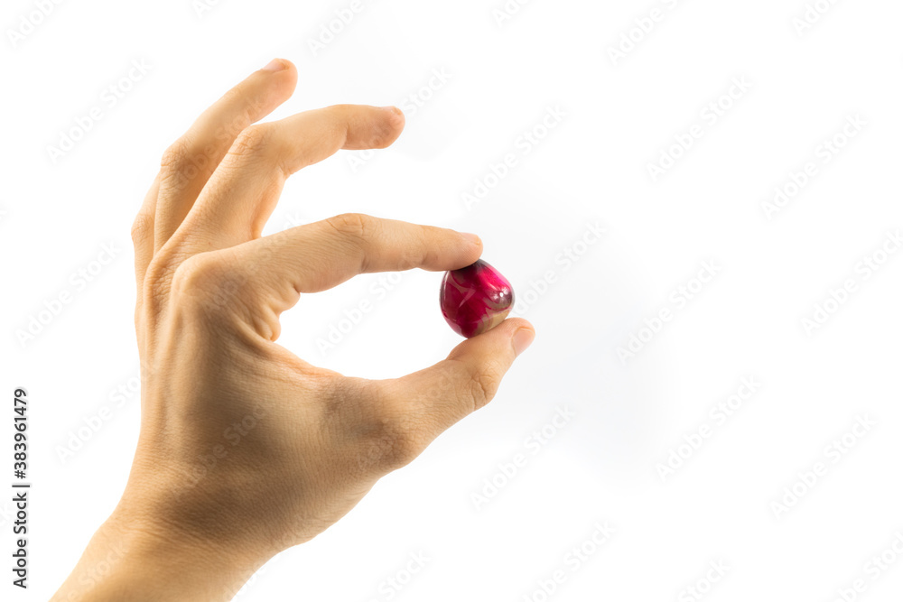 Precious red stone in judging hand on white isolated background Precious red stone in judging hand on white isolated background