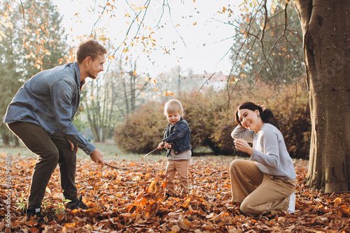 Family playing in autumn park having fun. © dsheremeta