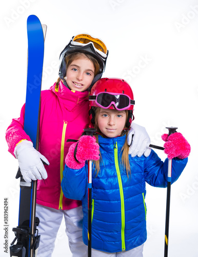 siters kid girls with ski poles helmet and snow goggles photo