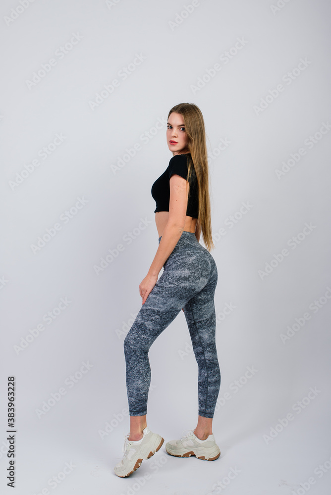 Full length portrait of smiling young fitness woman in perfect shape, studio shot Full length portrait of smiling young fitness woman in perfect shape, studio shot