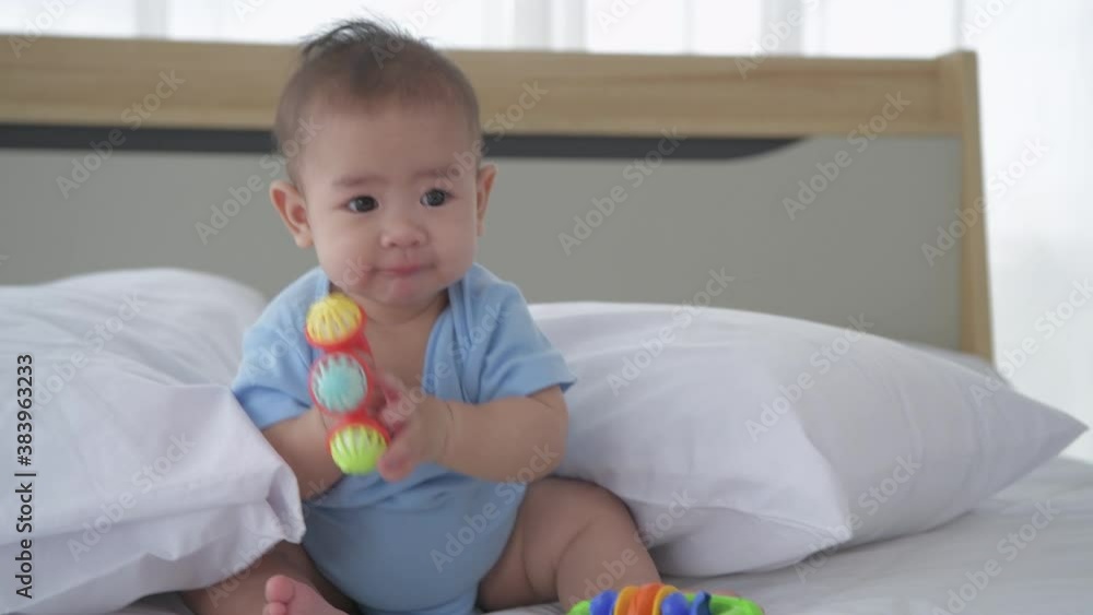 Family concept. The baby is lying alone playing with toys on the bed. 4k Resolution. Family concept. The baby is lying alone playing with toys on the bed. 4k Resolution.