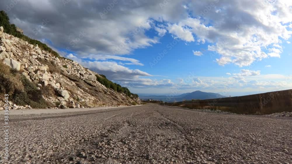 Fast tracking video from asphalt road perspective through a winding bumpy mountain road with with clear blue skies Fast tracking video from asphalt road perspective through a winding bumpy mountain road with with clear blue skies