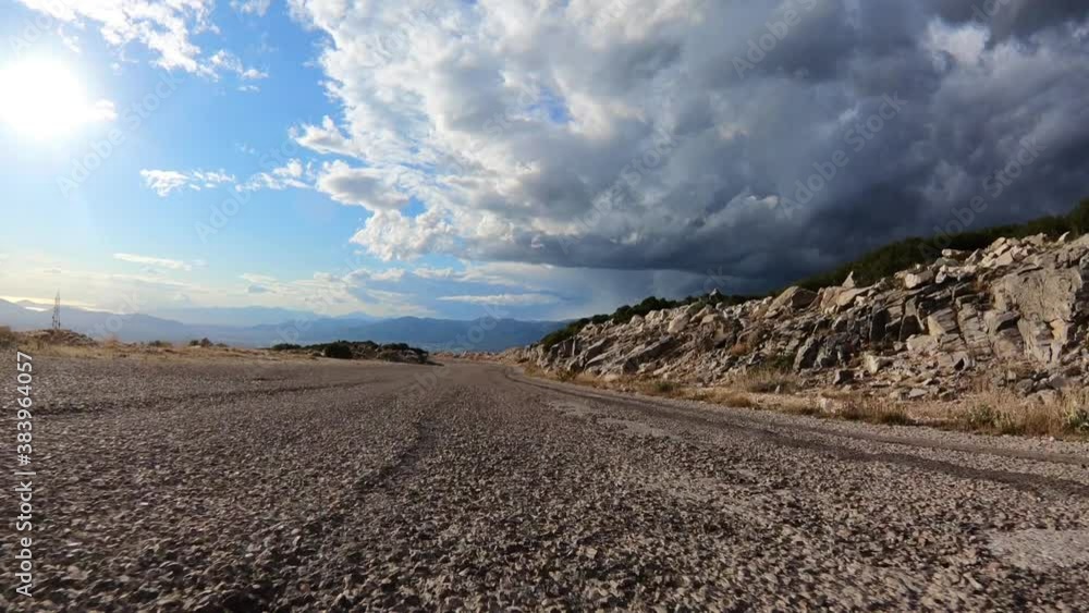 Fast tracking video from asphalt road perspective through a winding bumpy mountain road with with clear blue skies Fast tracking video from asphalt road perspective through a winding bumpy mountain road with with clear blue skies