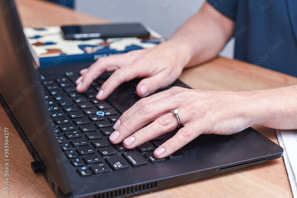 Woman working at home typing on a laptop computer keyboard Woman working at home typing on a laptop computer keyboard