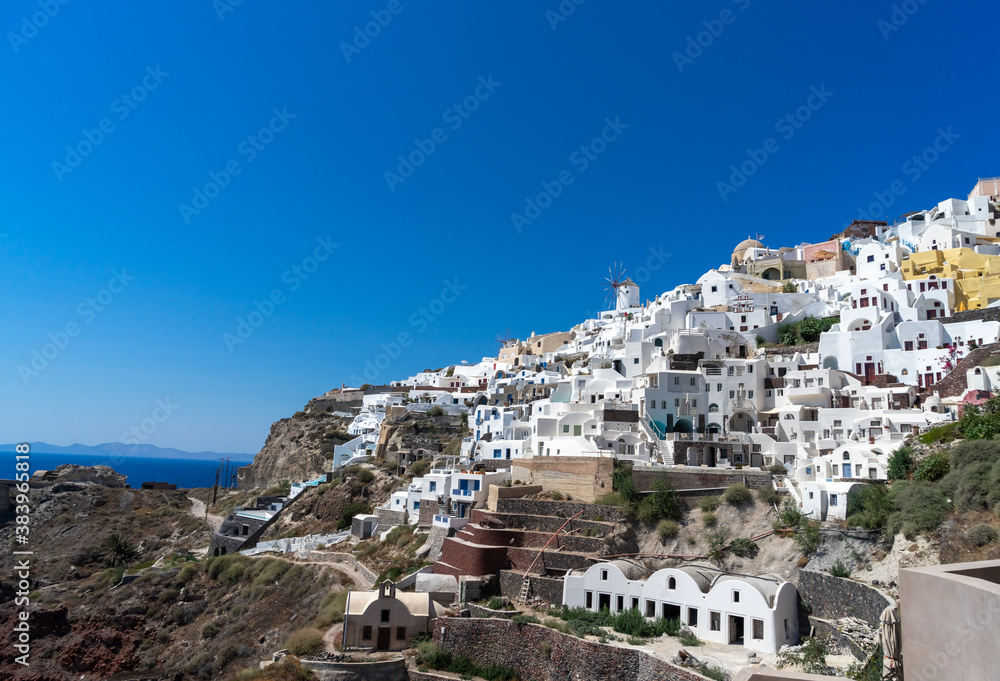 Panoramic view of Oia town in Santorini island with old whitewashed houses and traditional windmill, Greece Greek landscape on a sunny day