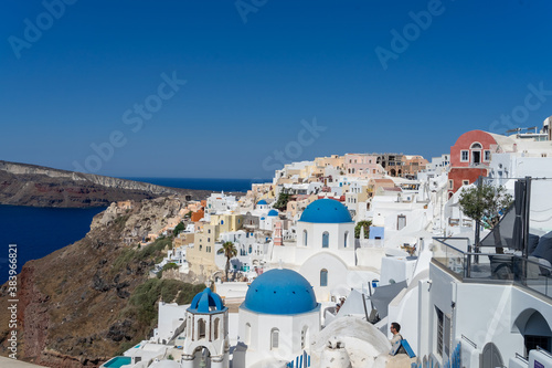 View of Santorini, with typical blue dome church, old whitewashed houses and caldera