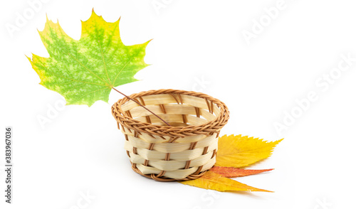 Beautiful autumn composition wicker basket and leaves on white isolated background