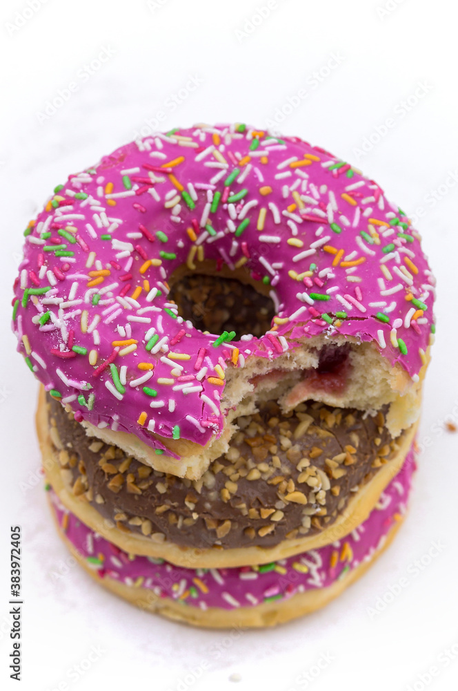 Pink and brown doughnut. Walnut donut on a white background.