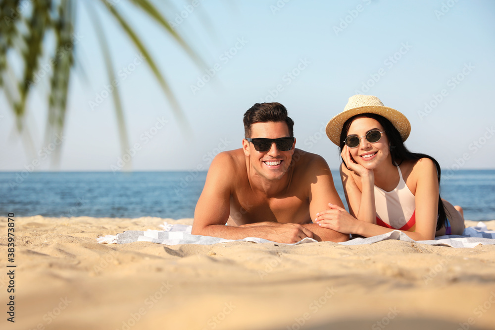 Fototapeta premium Happy couple resting on sunny beach. Space for text