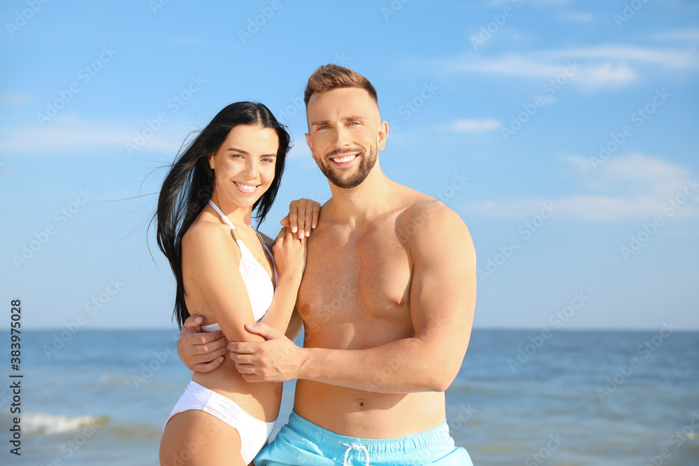 Happy young couple at beach on sunny day Happy young couple at beach on sunny day