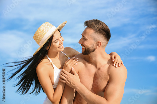 Happy young couple in beachwear on sunny day
