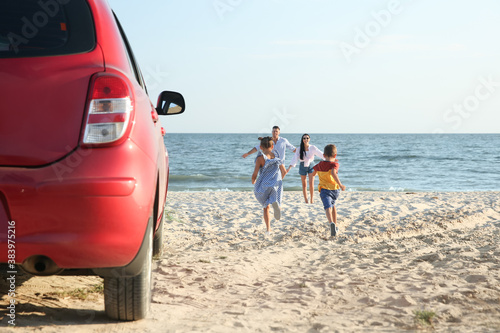 Little children running to their parents on sandy beach. Summer trip