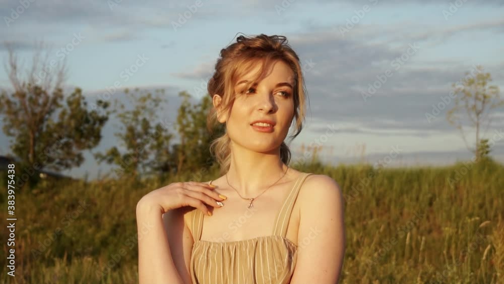 Pretty young woman standing at nature in the park and enjoy of sunset light. Slow motion Pretty young woman standing at nature in the park and enjoy of sunset light. Slow motion