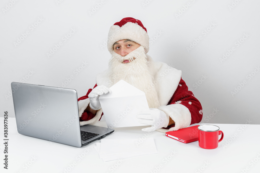 Santa Claus is sitting at his desk and reading letters. Santa Claus is sitting at his desk and reading letters.