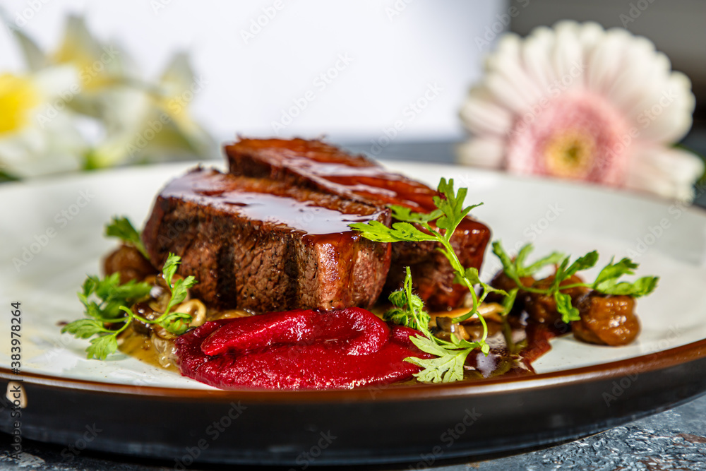 Grilled beef with mushrooms, mashed potatoes and beetroot sauce is on the plate Grilled beef with mushrooms, mashed potatoes and beetroot sauce is on the plate