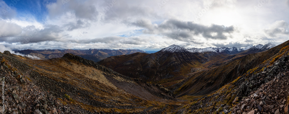 Beautiful Panoramic View of Scenic Mountains and Rocky Landscape in Canadian Nature. Season change from Fall to Winter. Taken in Tombstone Territorial Park, Yukon, Canada.