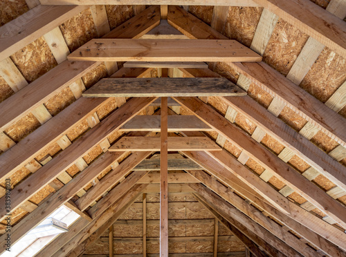 Attic of the house with wooden beams. Insulation of roofs and ceilings. Construction of houses.