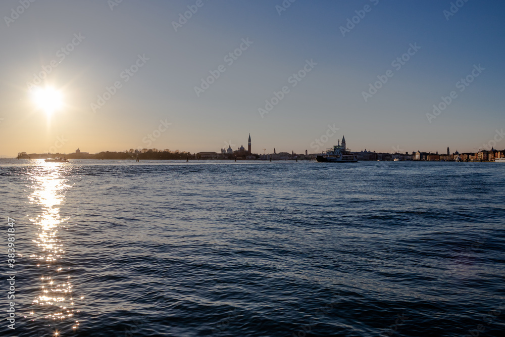 The sun sets over the Venetian lagoon and the distant San Giorgio Maggiore island
