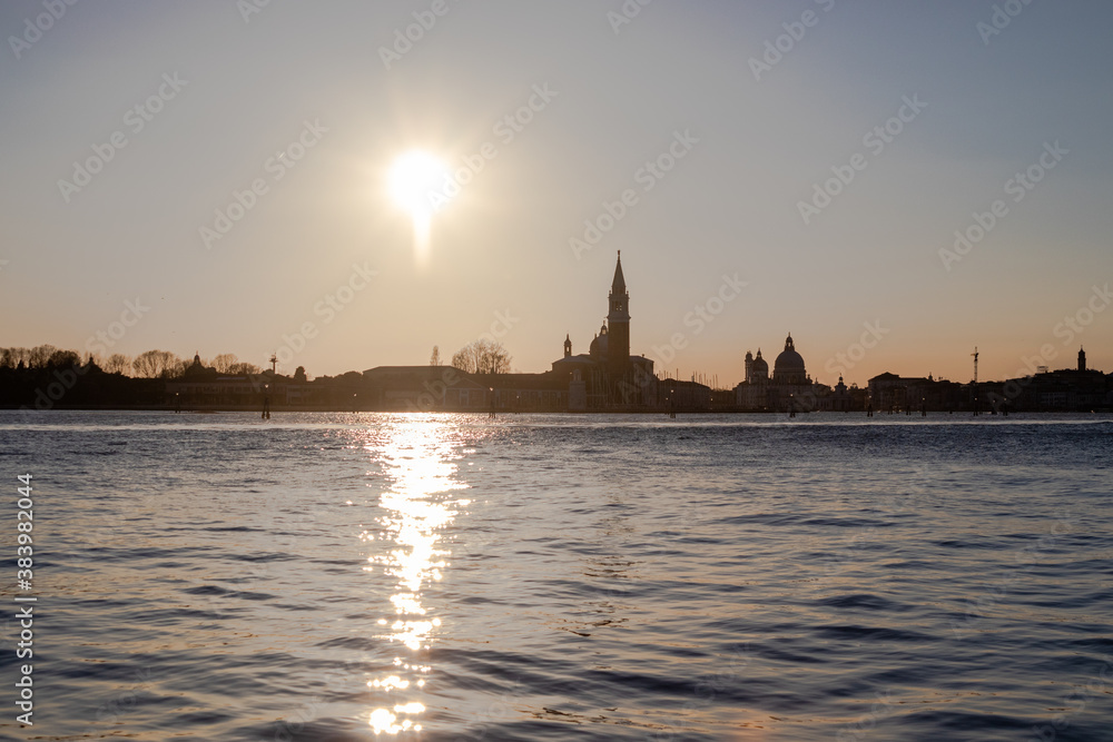 The setting sun beaming over the Venetian lagoon to the Church of San Giorgio Maggiore on the San Giorgio Maggiore island