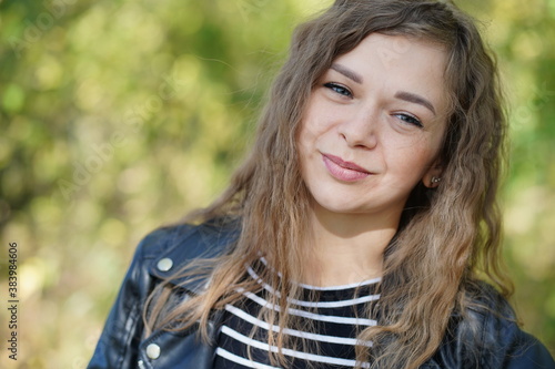 Close up of attractive young woman posing in wood. Charming female photographed on camera, standing in forest.