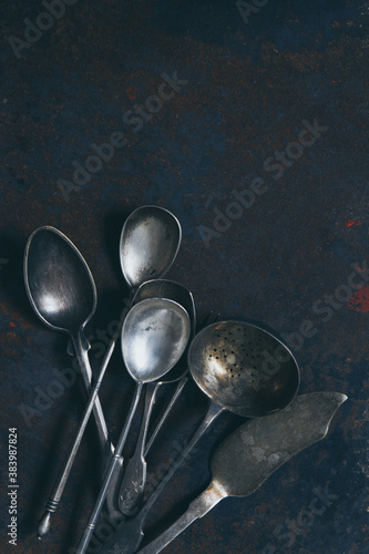 Silver set of vintage cutlery on a dark background, top view with a copy space © tartalja