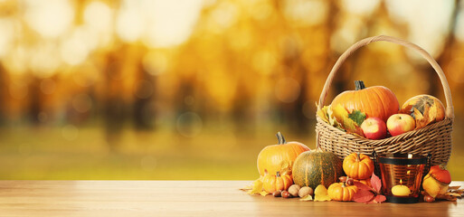 Happy Thanksgiving day. Fresh pumpkins, acorns, apples, walnuts and fallen leaves on wooden table outdoors, space for text