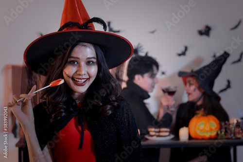 Portrait of witch woman holding sweetcandy snack, People going to Halloween party with spooky costume, makeup scary face, having fun at Halloween party by celebration